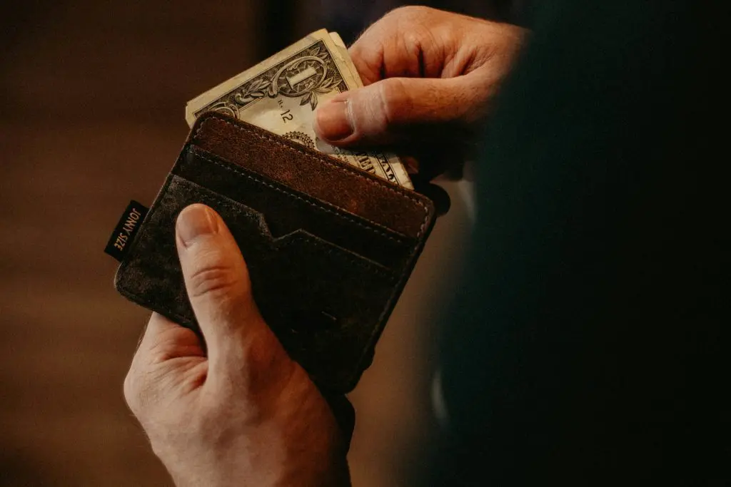 A person is taking money out of a wallet.